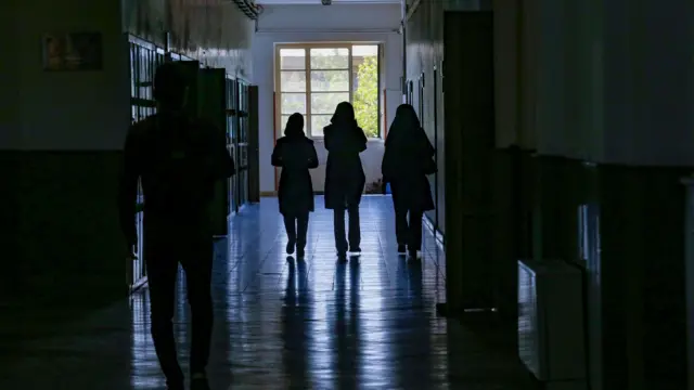 Male and female Iranian students walk through the halls of an Iranian university