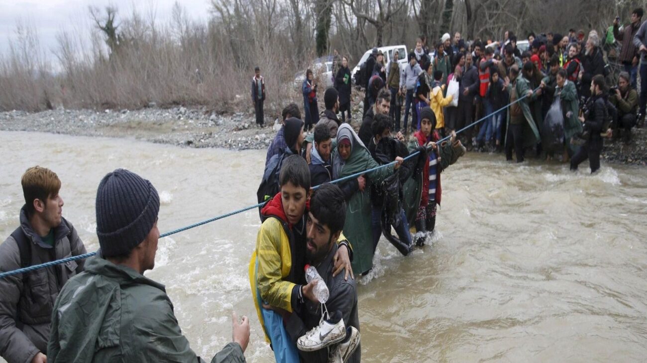 Refugees crossing a river near the Greek-Macedonian border west of the Greek village of Idomeni in early 2014 (Reuters)